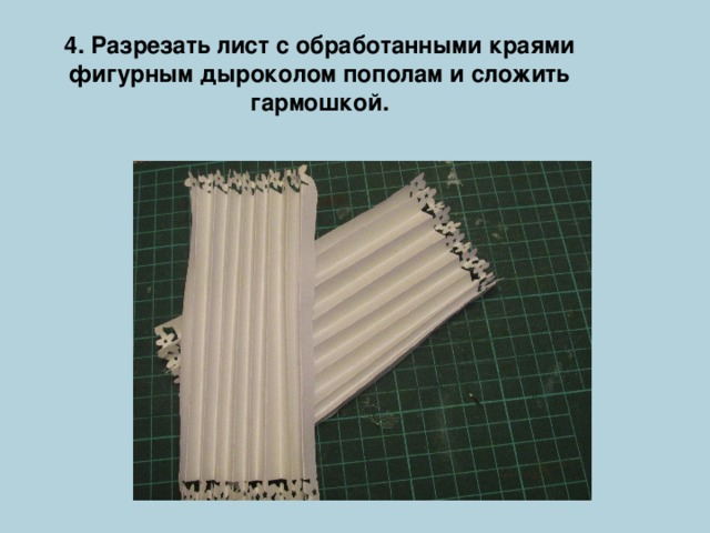 4. Разрезать лист с обработанными краями фигурным дыроколом пополам и сложить гармошкой. 