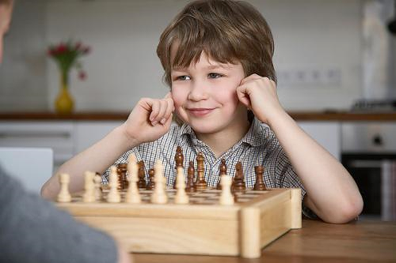 The boy playing chess. Шахматы для детей. Игра в шахматы дети. Мальчик с шахматами. Мальчик играет в шахматы.