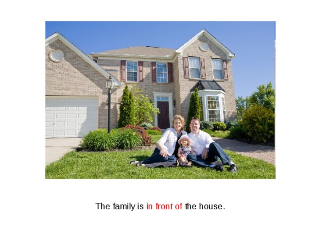 The family is in front of the house. 