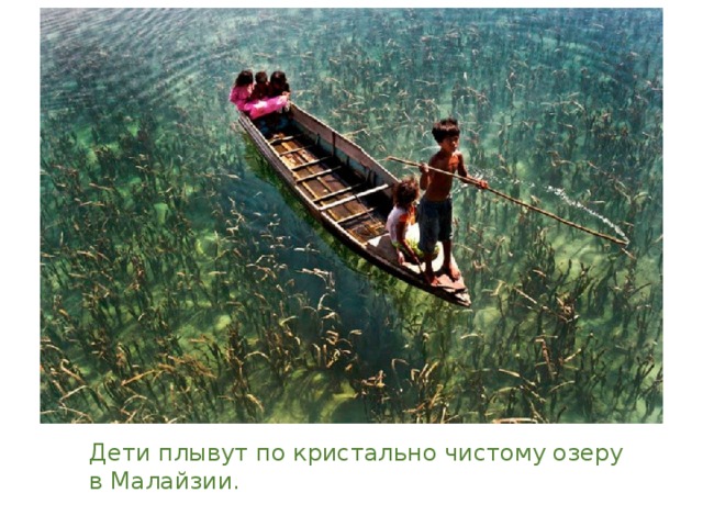 Дети плывут по кристально чистому озеру в Малайзии. 