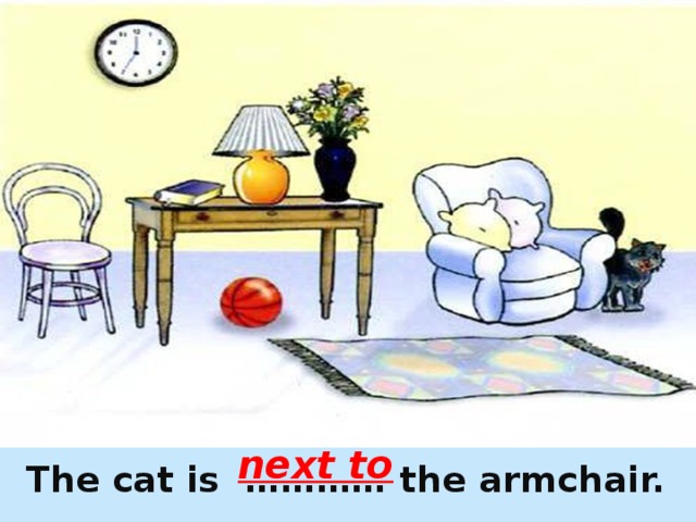 next to  The cat is ………… the armchair. 