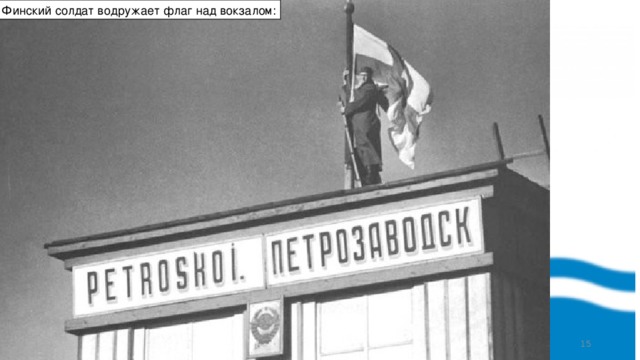 Финский солдат водружает флаг над вокзалом:  