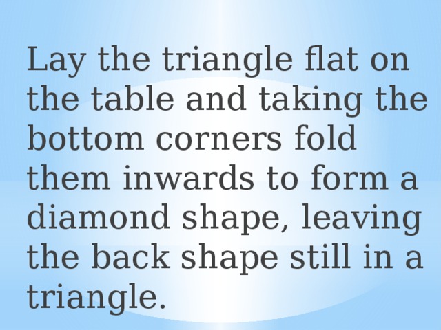 Lay the triangle flat on the table and taking the bottom corners fold them inwards to form a diamond shape, leaving the back shape still in a triangle. 