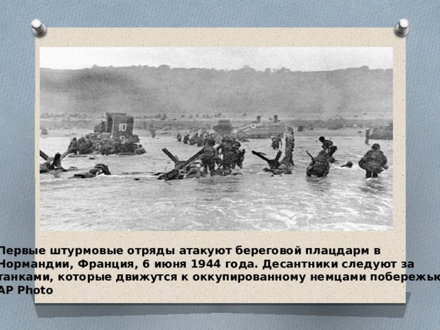 Первые штурмовые отряды атакуют береговой плацдарм в Нормандии, Франция, 6 июня 1944 года. Десантники следуют за танками, которые движутся к оккупированному немцами побережью. AP Photo 