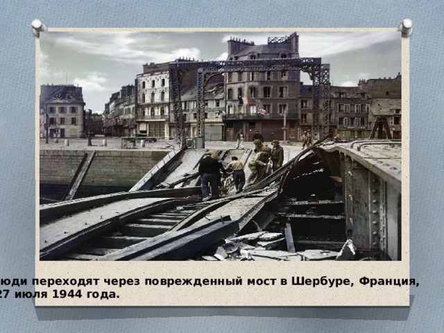 Люди переходят через поврежденный мост в Шербуре, Франция,  27 июля 1944 года. 