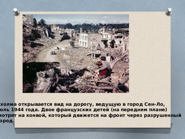 С холма открывается вид на дорогу, ведущую в город Сен-Ло, июль 1944 года. Двое французских детей (на переднем плане) смотрят на конвой, который движется на фронт через разрушенный  город. 