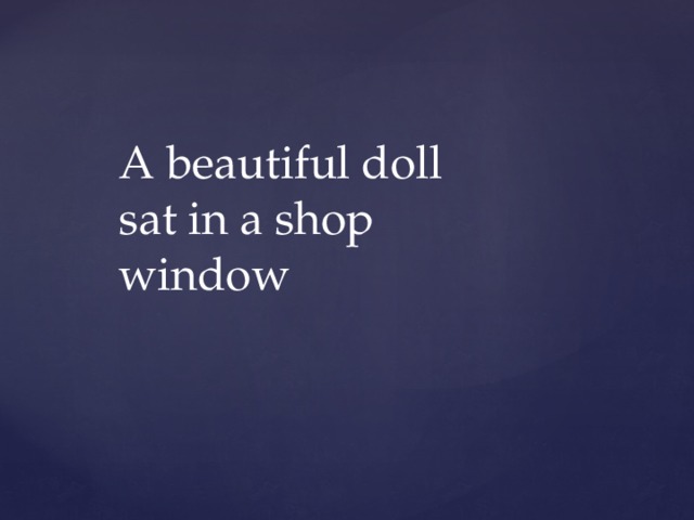 A beautiful doll sat in a shop window 