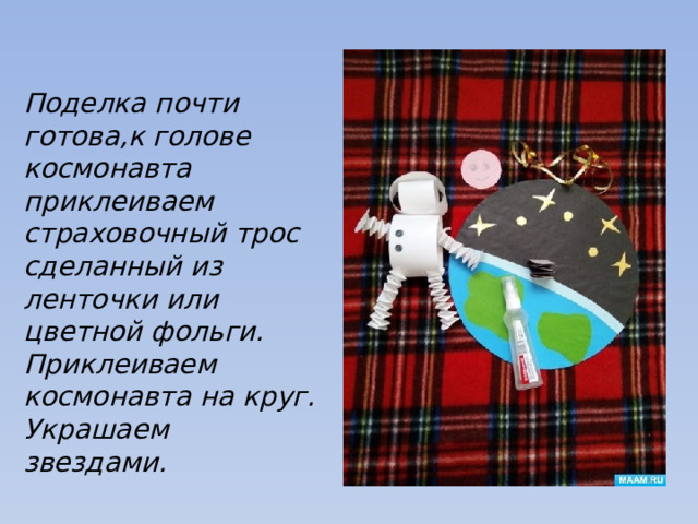 Поделка почти готова,к голове космонавта приклеиваем страховочный трос сделанный из ленточки или цветной фольги. Приклеиваем космонавта на круг. Украшаем звездами. 