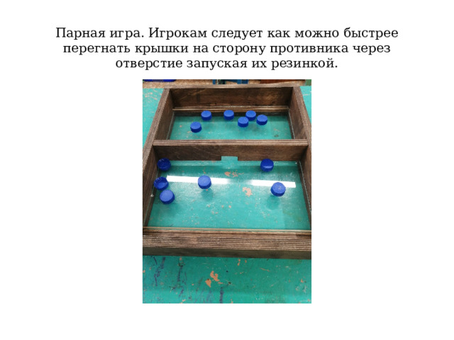 Парная игра. Игрокам следует как можно быстрее перегнать крышки на сторону противника через отверстие запуская их резинкой. 